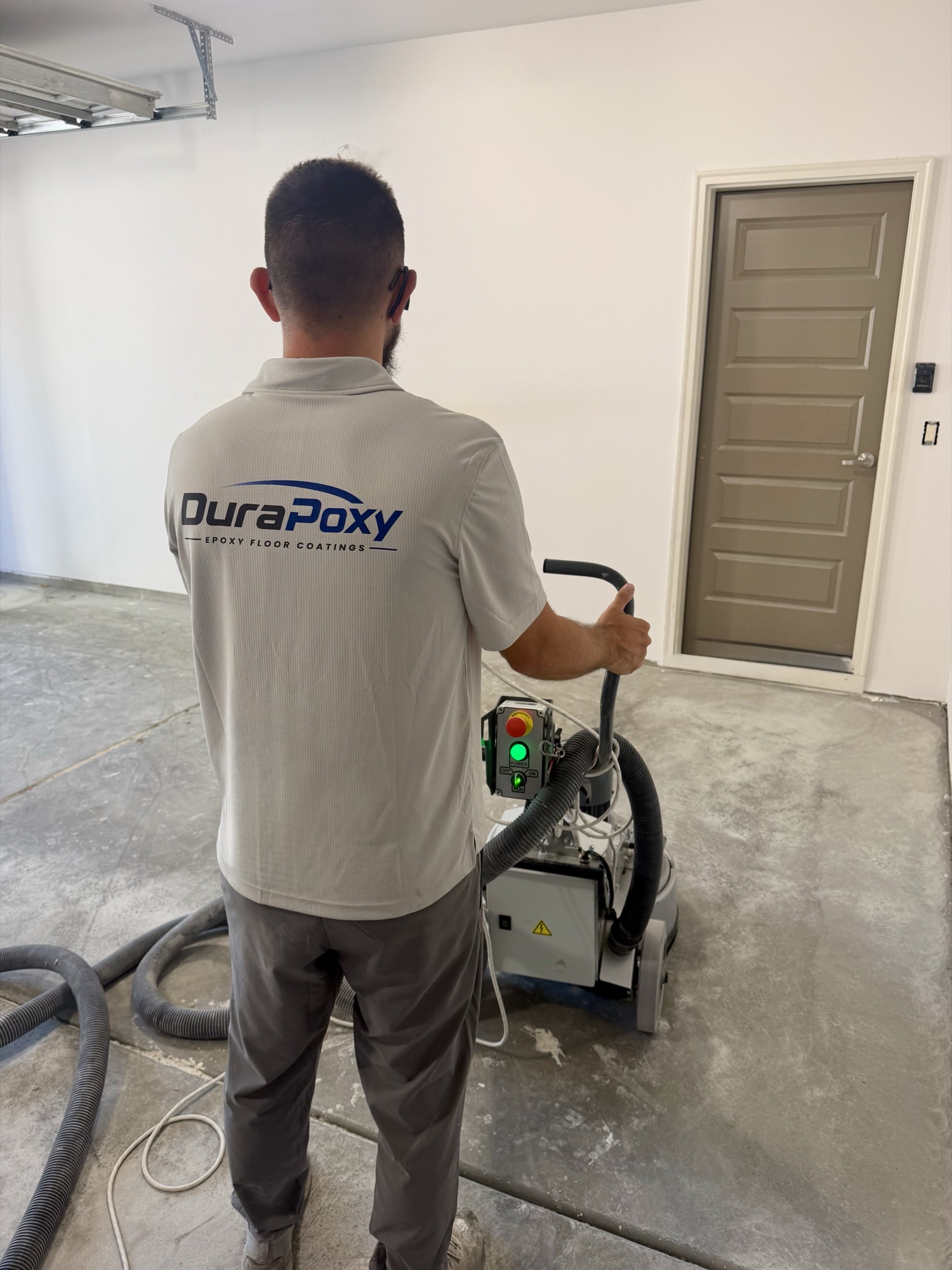 DuraPoxy technician grinding and prepping a garage floor before coating